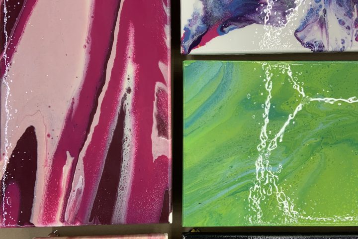 Abstract art with colorful fluid patterns in pink, blue, green, and black on five canvases.